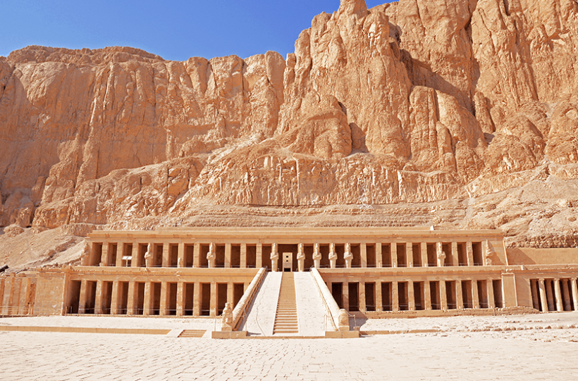 The Mortuary Temple of Hatshepsut with its grand colonnade and staircase set against towering cliffs.