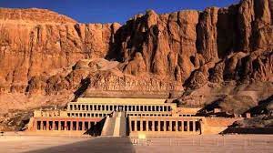 Hatshepsut Temple nestled against rocky cliffs in Luxor, Egypt, bathed in golden light.
