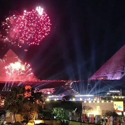 Fireworks lighting up the night sky above the Pyramids of Giza during a New Year's celebration.