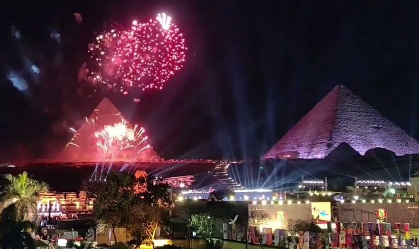 Fireworks lighting up the night sky above the Pyramids of Giza during a New Year's celebration.